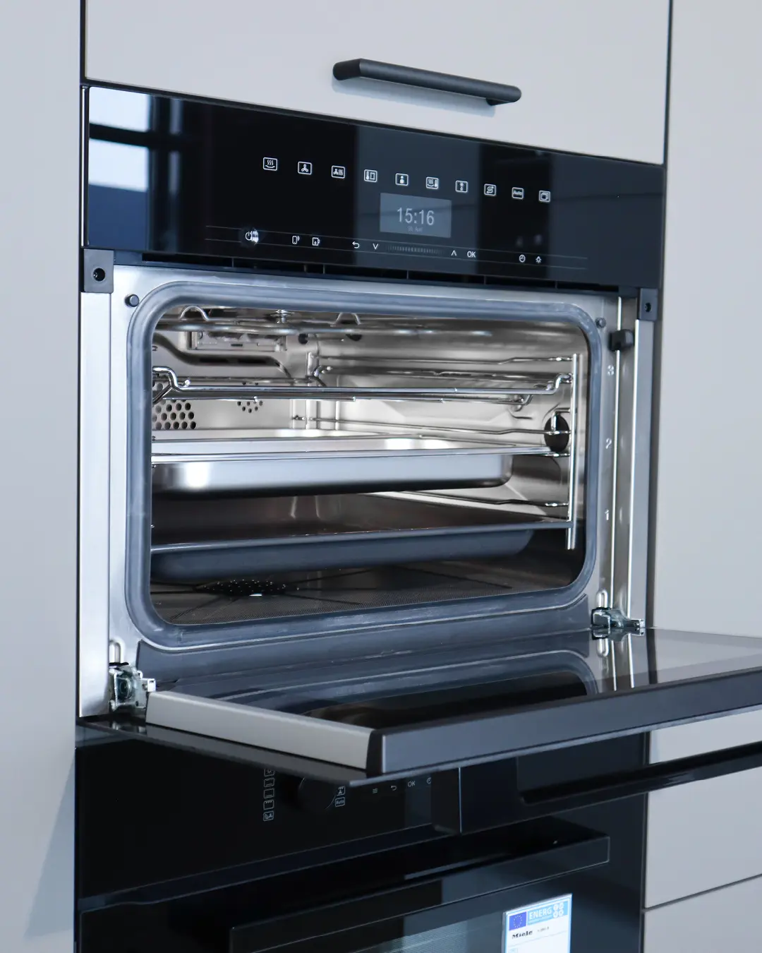 Geöffneter Einbaubackofen mit Touch-Display in der grauen Nobilia Küche KFB12