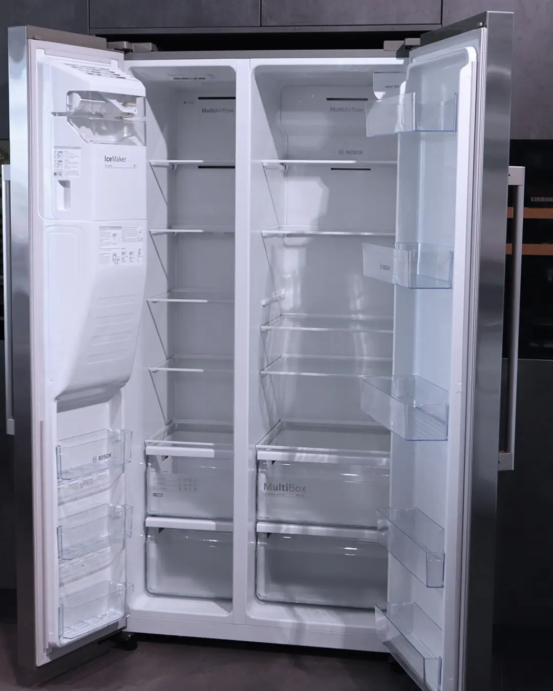 Geöffneter Side-by-Side-Kühlschrank von Bosch mit IceMaker und MultiBox in der grifflosen Häcker Küche in Betonoptik