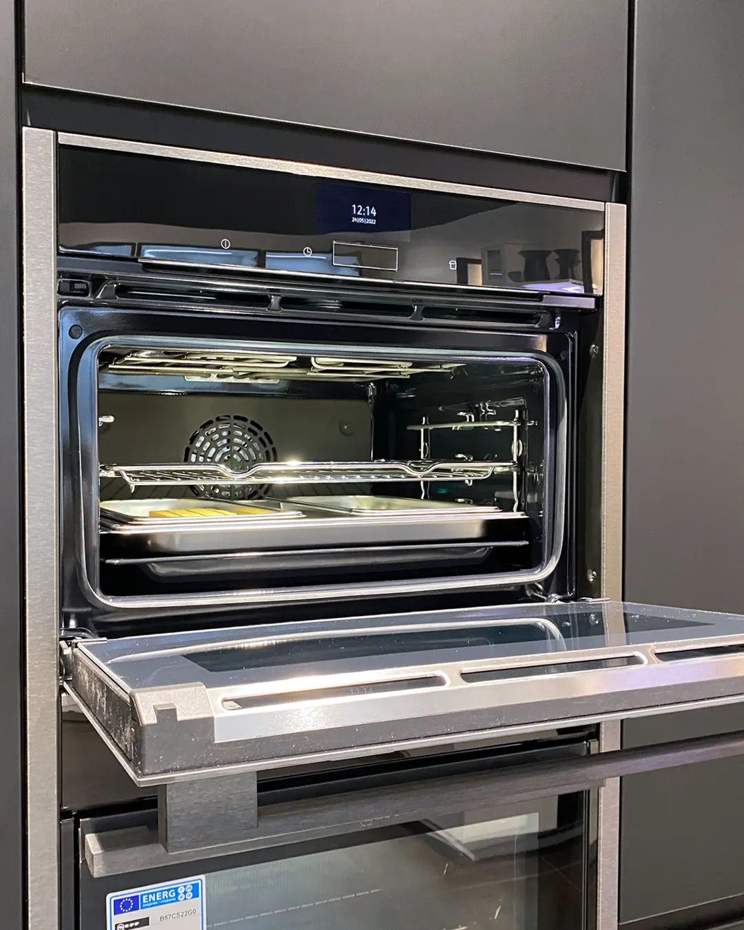 Geöffneter Einbaubackofen mit Backblechen und Display in der Nobilia Küche KSD13