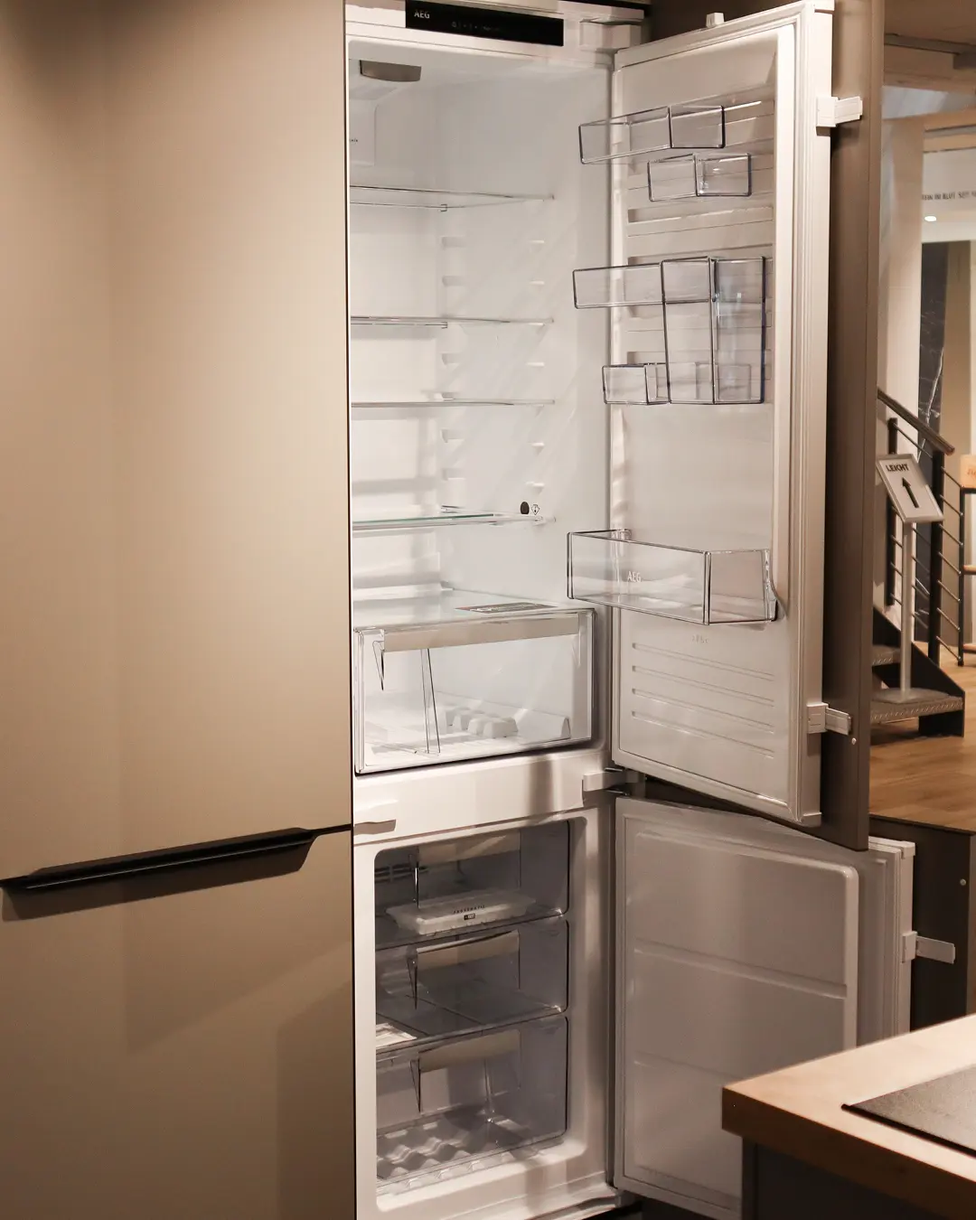 Geöffneter Einbaukühlschrank mit Gefrierfach in der beige-grauen Nobilia Küche KSH14