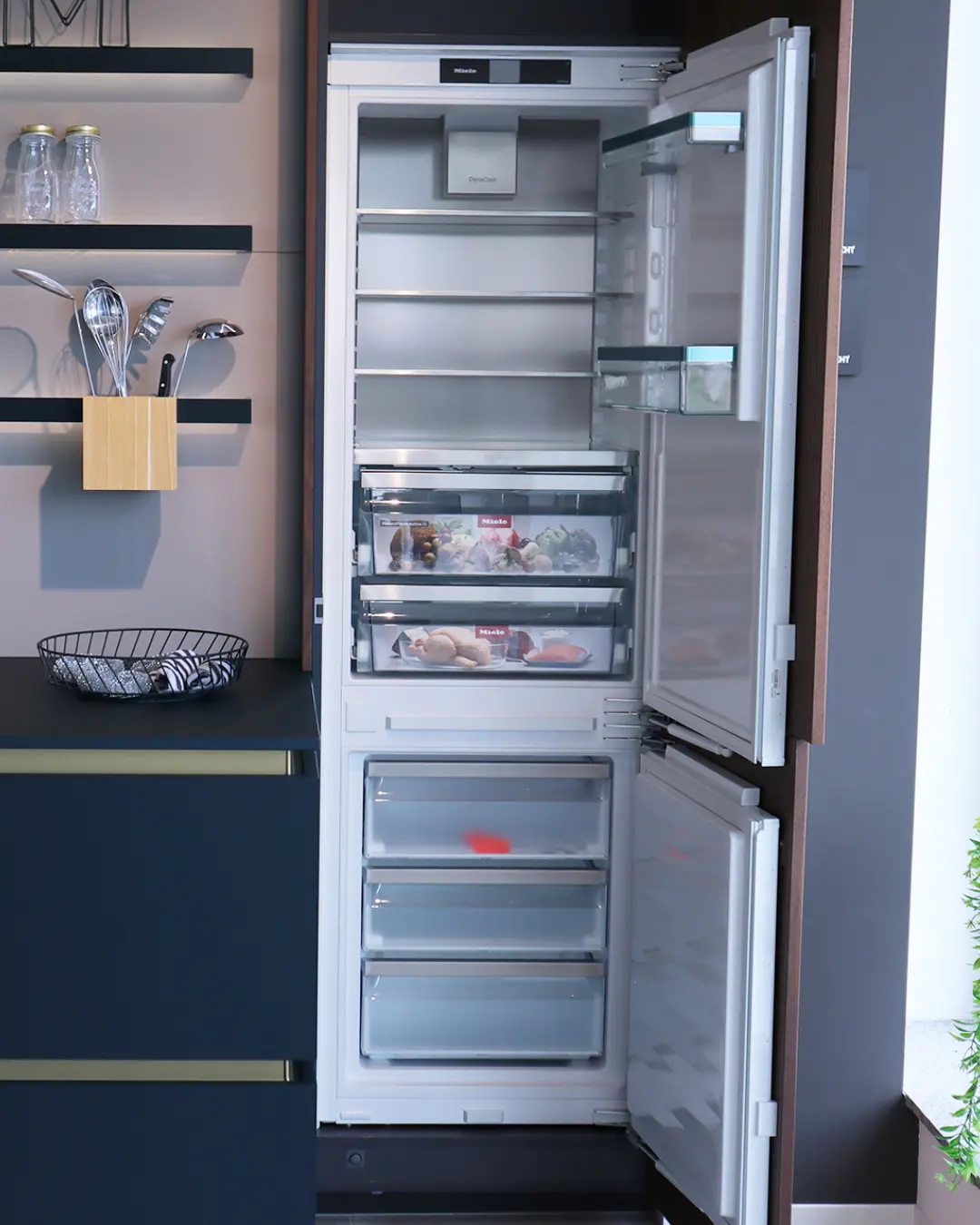Geöffneter Einbaukühlschrank mit Gefrierteil von Miele in der schwarzen grifflosen Leicht Küche KBK18