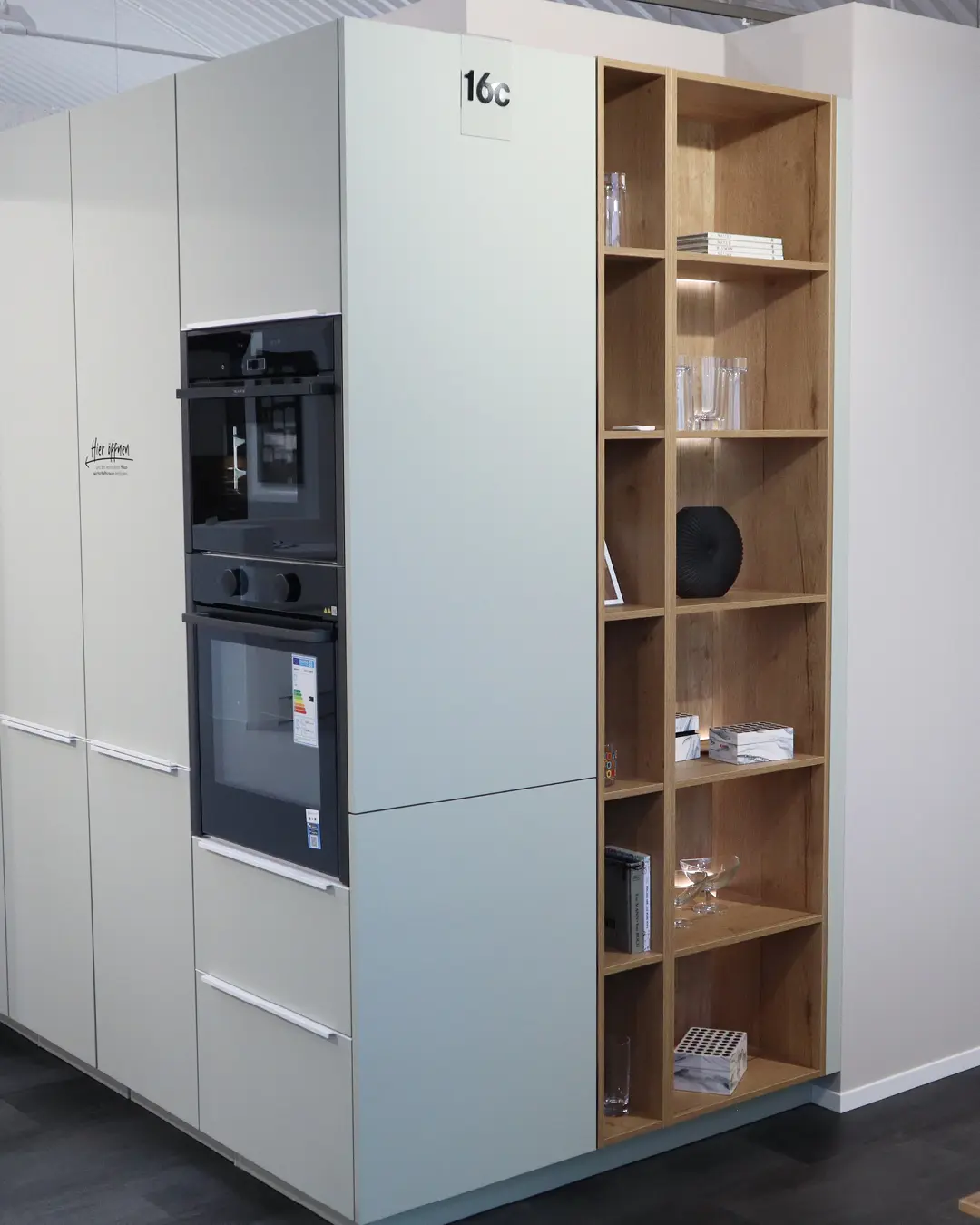 Hochschrankzeile der weiß-grauen Nobilia Küche KFB16 mit Backofen, Kaffeevollautomat und offenem Regal in Holzoptik