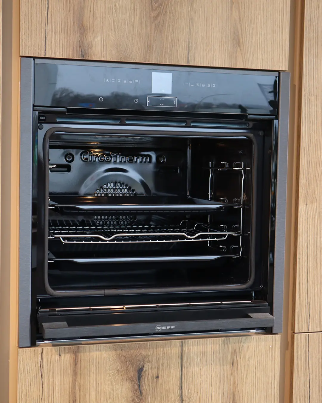 Geöffneter Neff-Einbaubackofen in Hochschrank in Holzoptik der grifflosen Leicht Küche KBK19