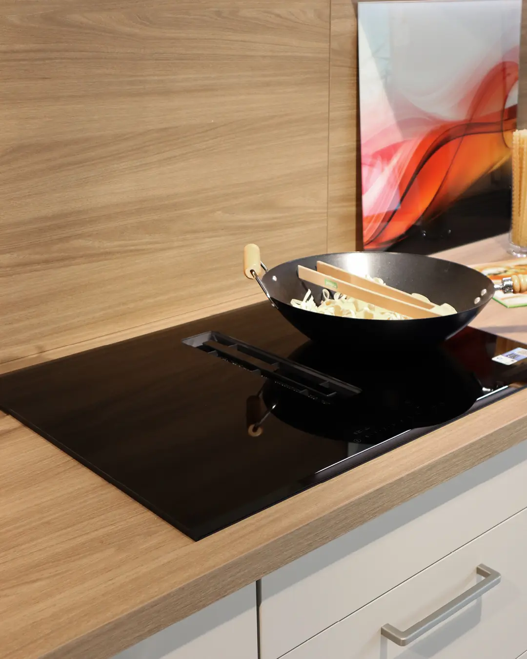 Induktionskochfeld mit Wok auf Arbeitsplatte in Holzoptik der Leicht Küche Kaschmir Beige in L-Form