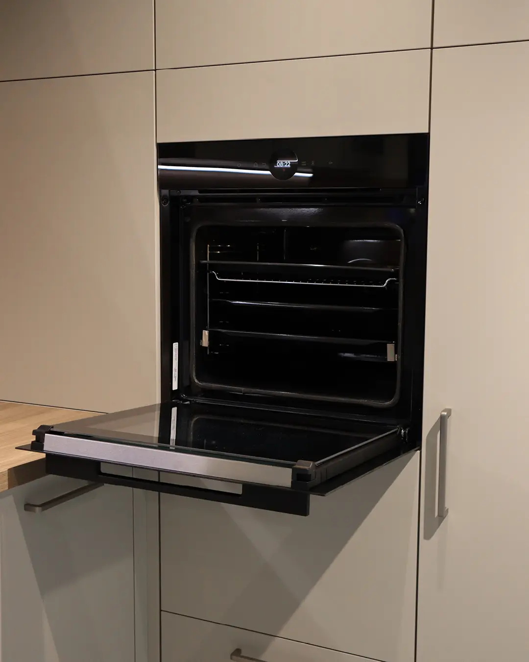 Geöffneter Einbaubackofen in der Kaschmir Beige Leicht Küche in L-Form, eingebaut in einen Hochschrank