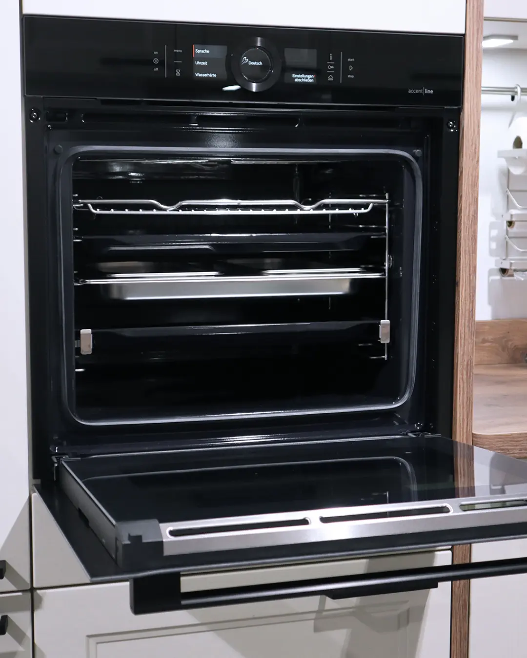 Geöffneter Einbaubackofen mit Display in der Landhausküche in Crema-Magnolie von Häcker