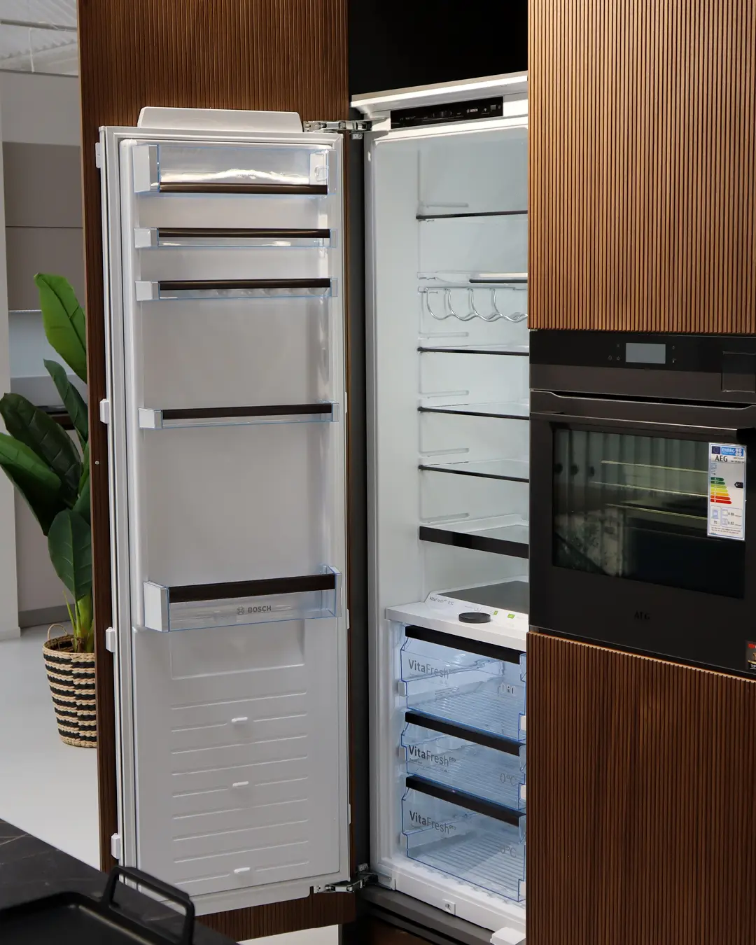 Häcker Küche in Graphit und Nussbaum: offener Einbaukühlschrank von Bosch neben AEG-Backofen im Hochschrank