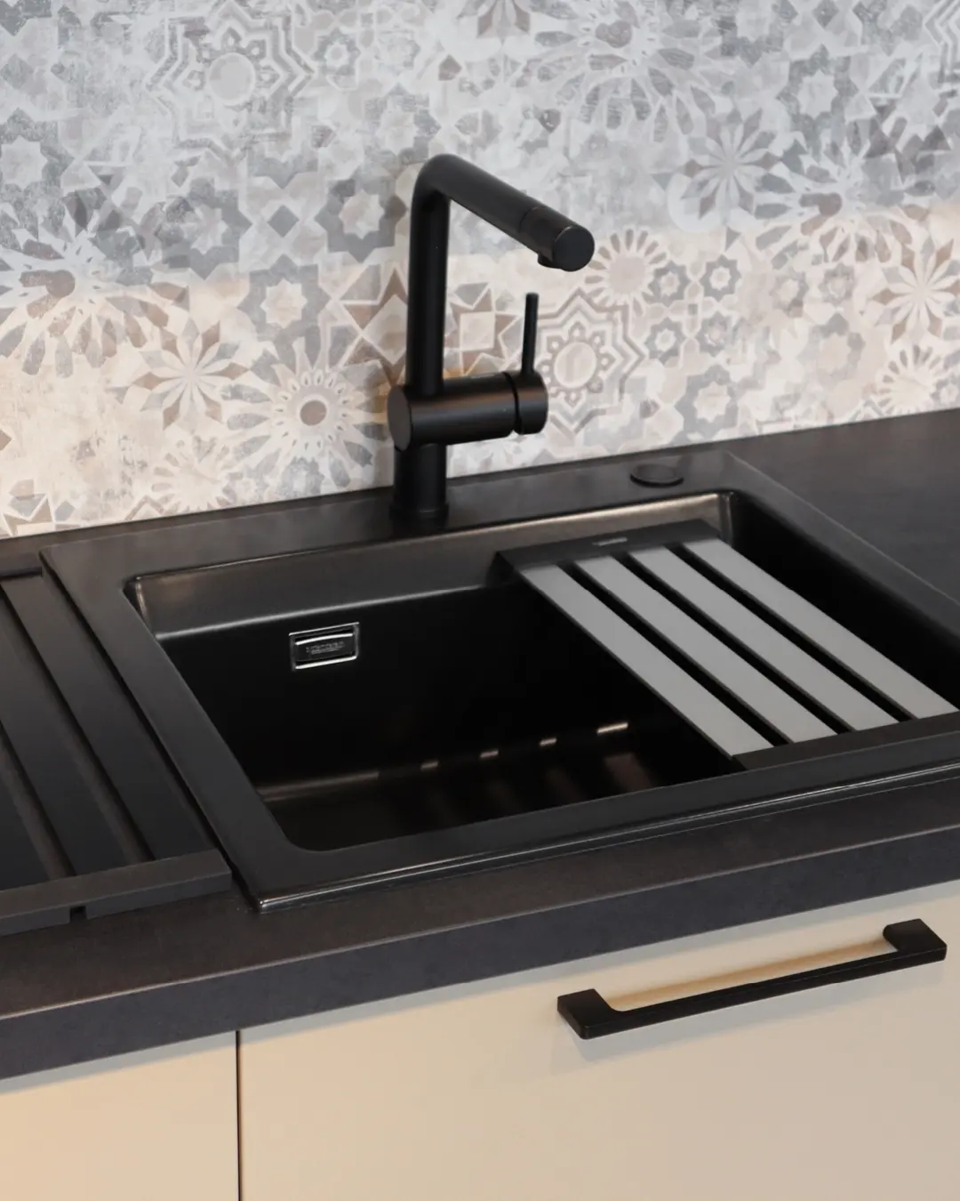 Schwarze Spüle mit Abtropffläche und schwarzer Armatur in der beige-braunen Häcker Küche in L-Form