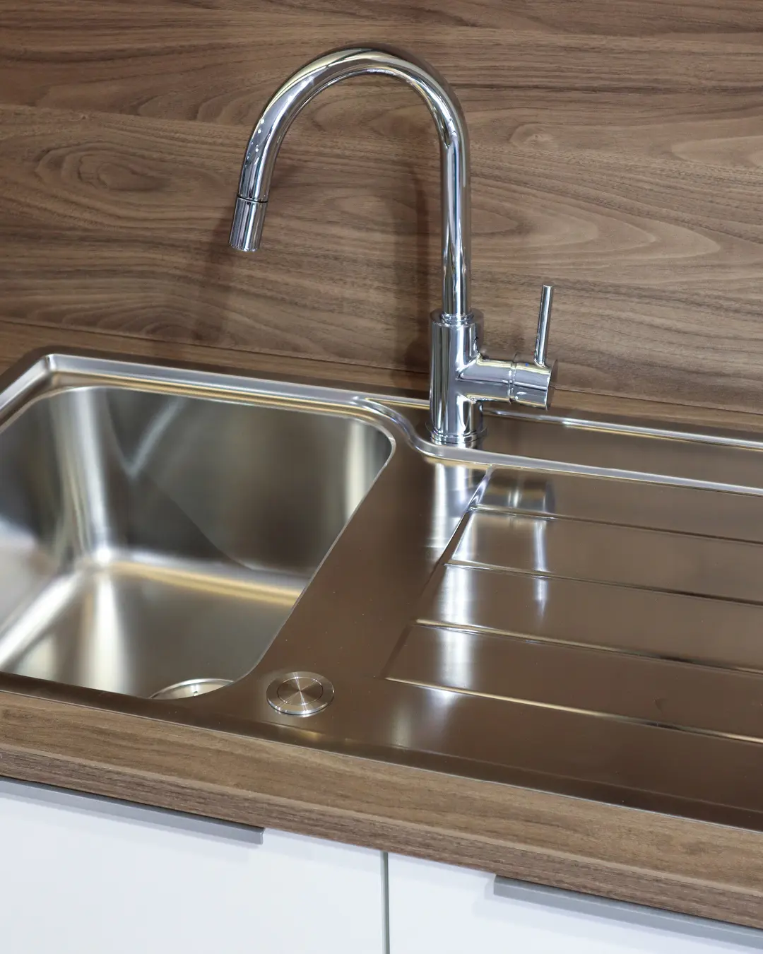 Edelstahlspüle mit Abtropffläche und Chrom-Armatur in Arbeitsplatte in Holzoptik der Häcker Küche KFB5