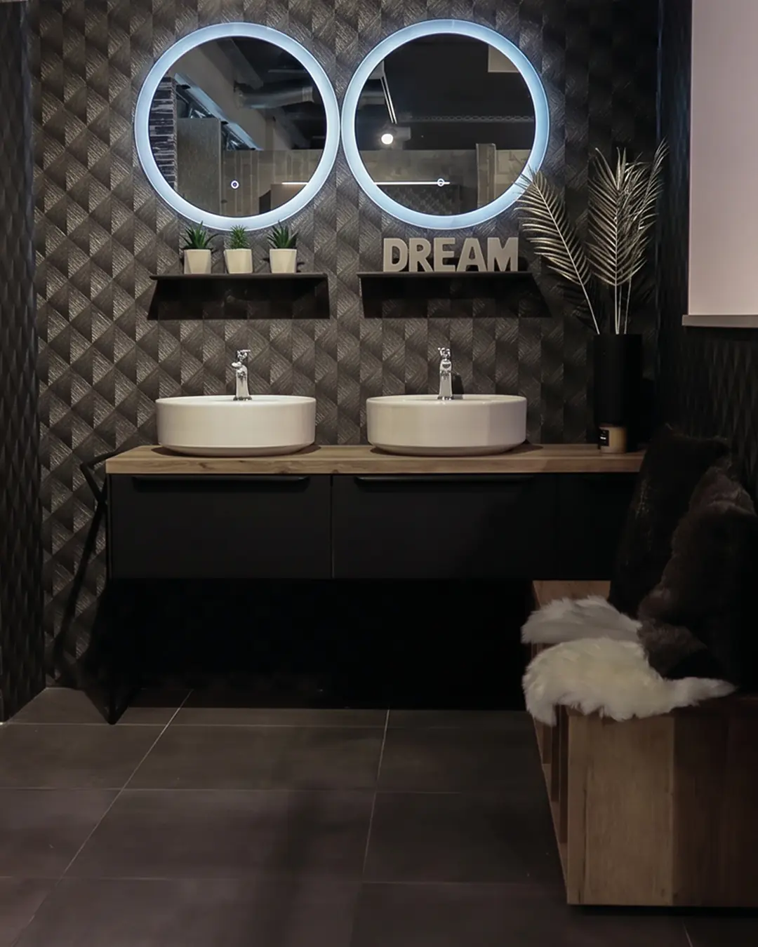 Schwarze Nobilia Badmöbel mit zwei Aufsatzbecken, Waschtischplatte in Holzoptik, runden LED-Spiegeln und Deko-Schriftzug "DREAM"