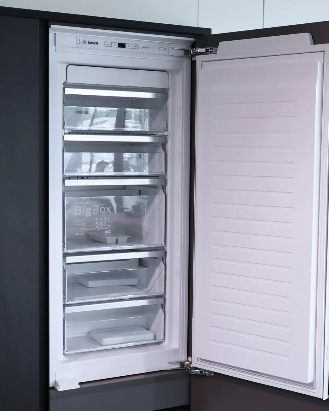Geöffneter Einbau-Gefrierschrank von Bosch mit BigBox-Schublade in weißer Häcker Küche